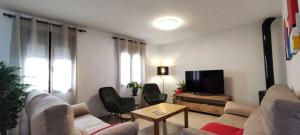 - un salon avec un canapé et une télévision dans l'établissement Casa La Oliva, à Albanchez de Úbeda
