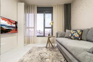 a living room with a couch and a window at jerusalem luxury apartment in Jerusalem