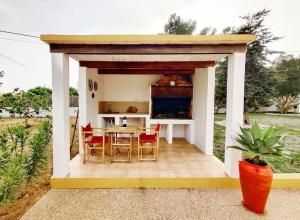 einen kleinen Pavillon mit einem Tisch und Stühlen in der Unterkunft Bonita Casa con piscina privada y amplio jardin in Sant Francesc de s'Estany