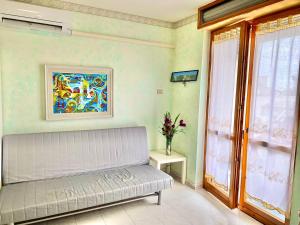 a living room with a couch and a window at Residenza Tigli Campomarino Lido in Campomarino