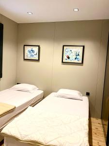 2 Betten in einem Zimmer mit 2 Bildern an der Wand in der Unterkunft Red Wine in Ulcinj