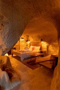 una camera con un letto e un tavolo in una grotta di Feris Cave Hotel a Nevşehir