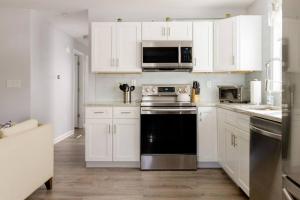 una cucina con armadietti bianchi e lavastoviglie nera di Luxury 3BD Condo in the heart of Providence a Providence