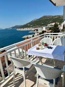 een tafel en stoelen op een balkon met uitzicht op het water bij Villa Senka in Neum