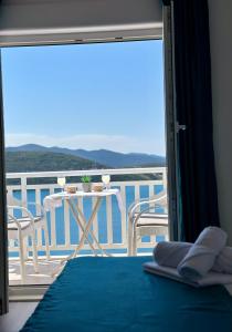 a room with a bed and a balcony with a table at Villa Senka in Neum