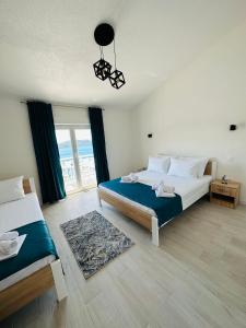 a bedroom with two beds and a large window at Villa Senka in Neum
