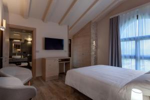 una camera d'albergo con letto e TV di Il Filo Rosso B&B ad Abano Terme