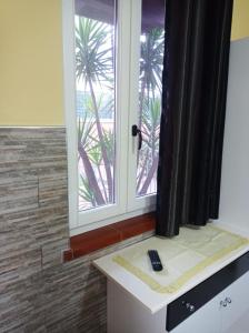 a bathroom with a window with a remote control on a counter at Casa Vacanze Mimose in Palinuro +77 photos