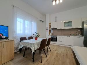 cocina y comedor con mesa y sillas en Holiday apartman, en Kaštela