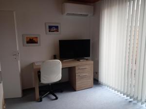 einen Computerschreibtisch mit Monitor und Stuhl in der Unterkunft 1 Zimmer Appartment in Springe