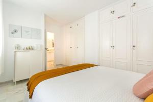 Un dormitorio blanco con una cama y una cocina. en Sherryflat Atípika, en Jerez de la Frontera