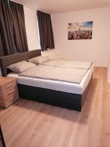 a large bed in a bedroom with a wooden floor at Altes Gesellenhaus in Dinklage