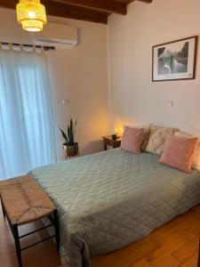 a bedroom with a large bed and a window at Perdika's Nest, family friendly house by the sea in Perdika
