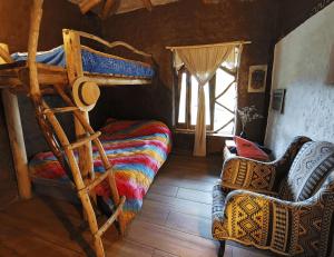 a bedroom with a bunk bed and a chair at Allpa Wasi - Casa Suaya La Esperanza in Ibarra