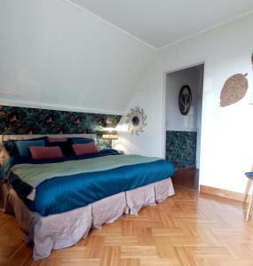 - une chambre dotée d'un grand lit avec des draps bleus dans l'établissement Gîte L'Escalier des Rêves - Rouen, à Le Mesnil-Esnard