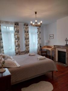 a bedroom with a large bed and a fireplace at La Maison de Léonie in Péronne