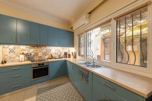 a kitchen with blue cabinets and a sink and windows at Historical Old Town - Casa d'Irene in Kos Town