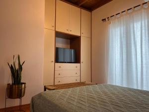 a bedroom with a bed and a tv on a cabinet at Perdika's Nest, family friendly house by the sea in Perdika
