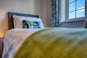 een bed met een kussen en een raam in een kamer bij Skelhorn House in Cosford