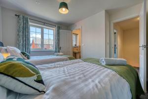 1 dormitorio con 2 camas y ventana en Skelhorn House en Cosford