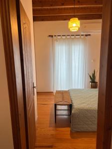 a bedroom with a bed and a window at Perdika's Nest, family friendly house by the sea in Perdika