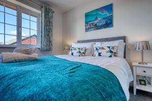 a bedroom with a large bed with a blue blanket at Skelhorn House in Cosford