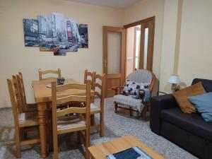 sala de estar con mesa, sillas y sofá en Precioso apartamento en Puerto de Sagunto Valencia, en Puerto Sagunto