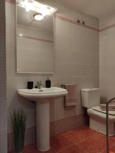 y baño con lavabo, aseo y espejo. en Precioso apartamento en Puerto de Sagunto Valencia, en Puerto Sagunto
