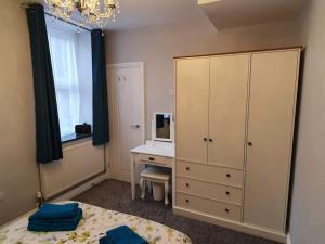 a bedroom with a bed and a dresser and a desk at Lynton old town, Central ground floor 1 bed apart. in Lynton