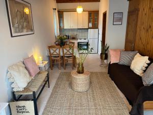 a living room with two couches and a kitchen at Perdika's Nest, family friendly house by the sea in Perdika
