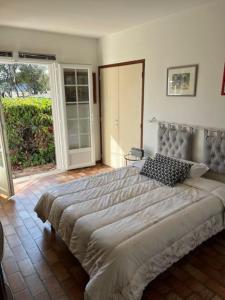ein Schlafzimmer mit einem großen Bett und einer Glasschiebetür in der Unterkunft Jolie Maison Piscine 8 mn à Pied du centre et Plage in Canet-en-Roussillon