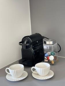 una macchinetta del caffè e due tazze su un bancone di Apartman Grand BW a Belgrado