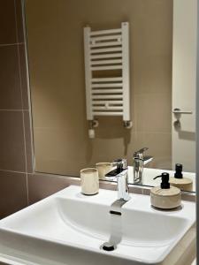 bagno con lavandino bianco e specchio di Apartman Grand BW a Belgrado