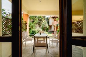 a patio with a table and chairs on a porch at BLACKHAUS PEFKOCHORI CHALKIDIKI Luxury VILLA in Pefkohori