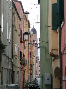 una calle de la ciudad con edificios y una cúpula en la distancia en VERDEPOESIA, en Chioggia