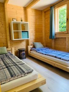 a room with two beds in a log cabin at Pomale Vendégház in Révfülöp