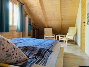 1 dormitorio con 1 cama y sillas en una habitación en Pomale Vendégház en Révfülöp