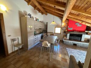 a kitchen and dining room with a table and a fireplace at Baita del Canton in Valdidentro