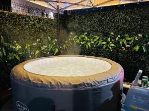 a large bath tub in a room with plants at Stunning House in Bristol - Hot Tub - Sleeps 10 in Bristol