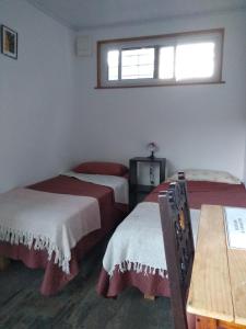 a room with three beds and a window at Aguaymanto in Cuchilla Alta