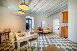 eine Küche und ein Wohnzimmer mit Tisch und Stühlen in der Unterkunft Aroucas Turismo e Natureza in Castro Marim