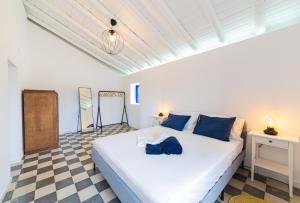 ein Schlafzimmer mit einem weißen Bett und einem karierten Boden in der Unterkunft Aroucas Turismo e Natureza in Castro Marim