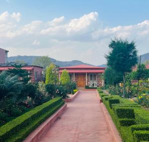a garden with a house and a walkway at DESI THATH RESORT in Alwar