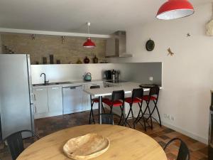 cocina con mesa de madera y cocina con nevera en La chambrette, en Bèze