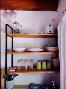 a kitchen shelf with plates and glasses on it at Cabañas Las Sirenas in Mar del Plata +20 photos