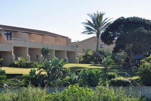 a building with a yard with trees and plants at Ocean Breeze in Amanzimtoti
