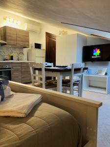una cucina e un soggiorno con tavolo e sedie di Talos Apartments a San Vito lo Capo