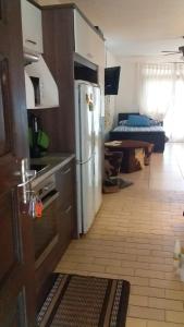 a kitchen with a refrigerator and a room with a bed at Ocean Breeze in Amanzimtoti