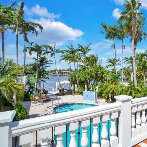uma varanda com piscina e palmeiras em The Pillars Hotel & Club em Fort Lauderdale