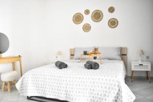 a bedroom with a white bed with two towels on it at Raeti Cretan Guesthouse in Moírai